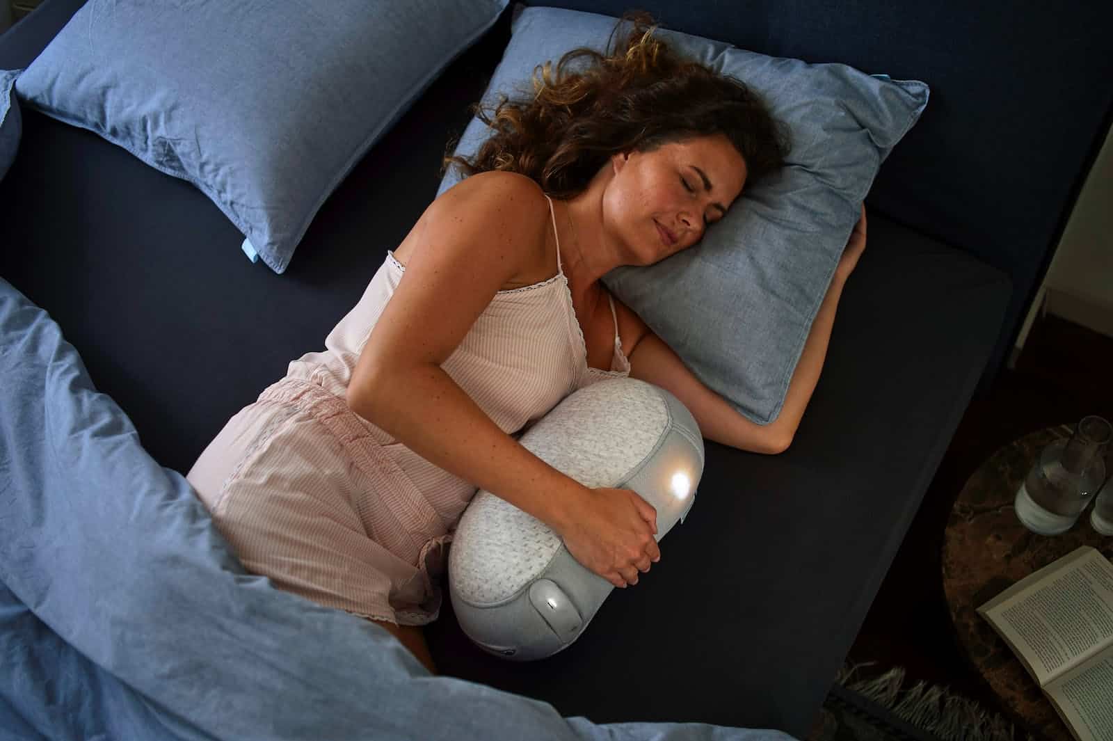 A Woman Hugging a Sleeping Robot while in Bed